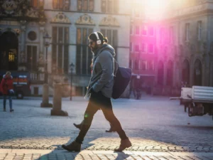 Man walking and listening to a podcast with headphones