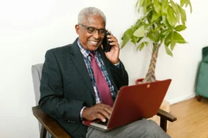 man smiling and sending an invoice on his laptop