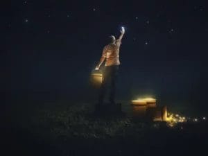 a man is standing in the dark holding a light in his hand .