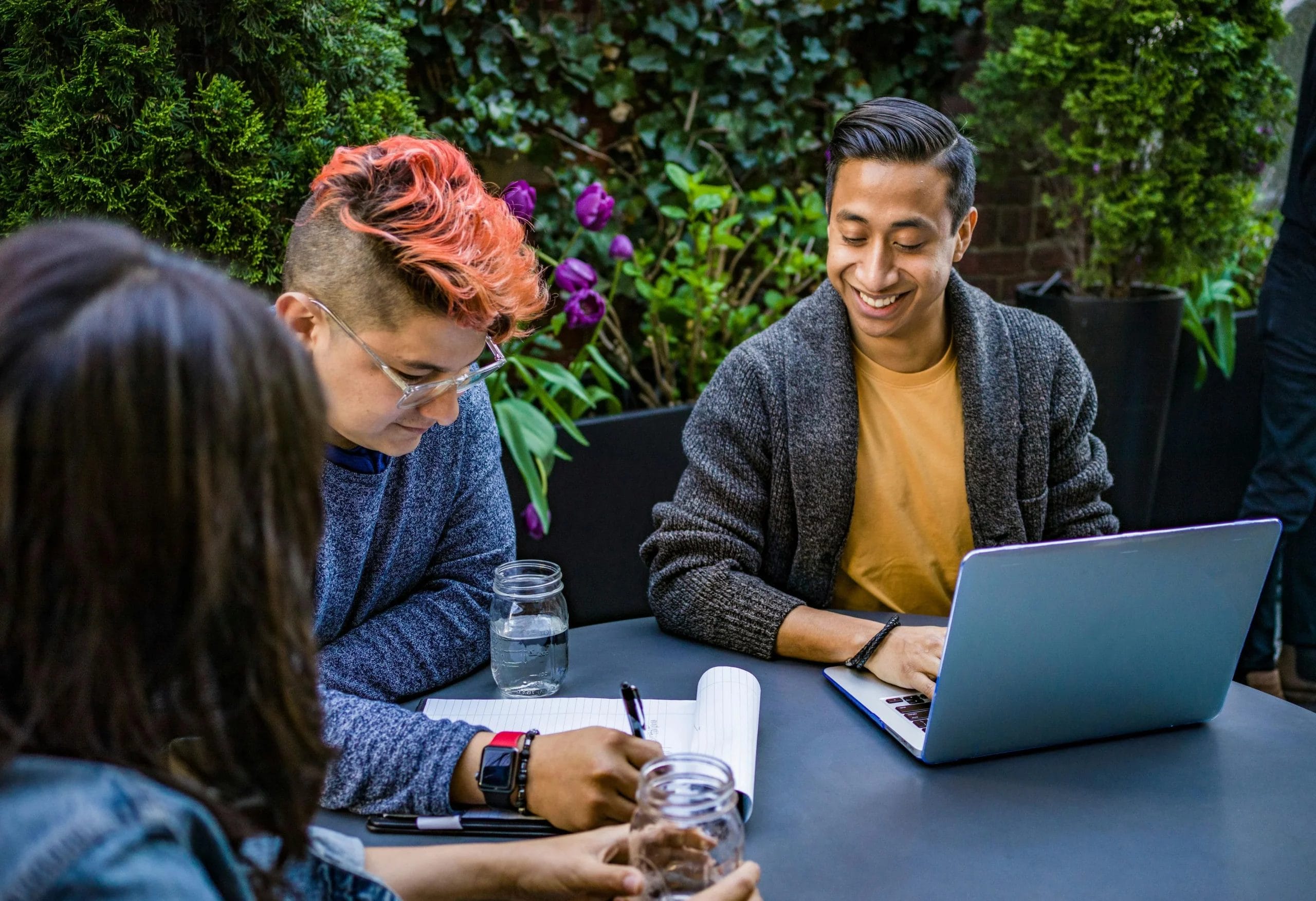 team collaborating on a project at a table outside