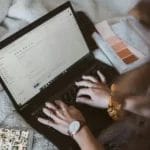 Woman typing on a laptop to send an email