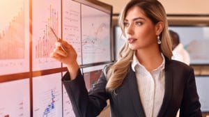a lady pointing on a graph with a pen
